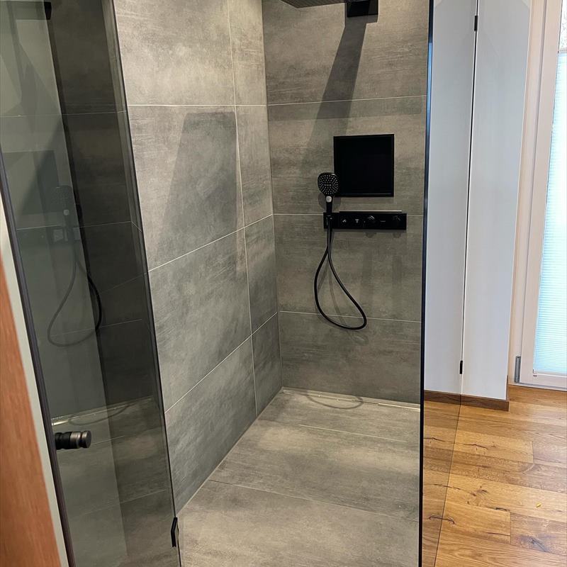 Dusche mit Glasabtrennung und schwarzen Armaturen