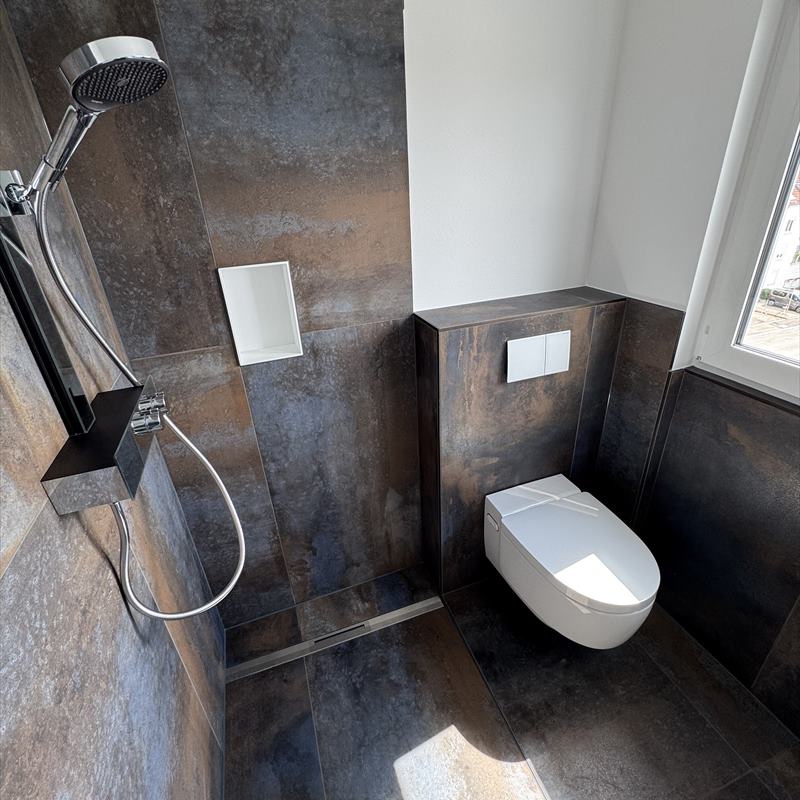 Bad in Metalloptik mit bodengleicher Dusche und wandhängendem WC